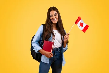 Foto op Plexiglas Happy caucasian teenager student woman, with Canada flag and book, enjoy exchange study © Prostock-studio