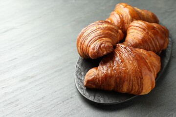 Delicious fresh croissants on grey table. Space for text