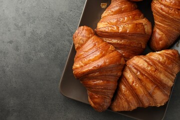 Delicious fresh croissants on grey table, top view. Space for text