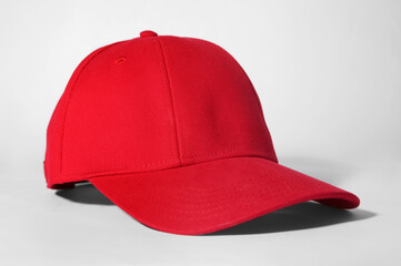 Stylish red baseball cap on white background