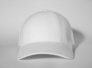 Stylish white baseball cap on light background