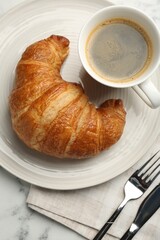 Delicious fresh croissant served with coffee on table, flat lay
