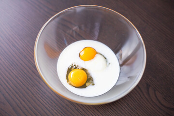  Close-Up of Eggs and Milk Ready to Mix in Glass Bowl