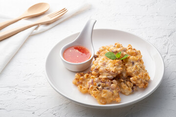 Deep fried Corn cake (Sweet Corn Fritters) on white plate with Chili sauce