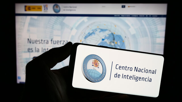Stuttgart, Germany - 11-12-2023: Person holding smartphone with logo of intelligency agency Centro Nacional de Inteligencia (CNI) in front of website. Focus on phone display.
