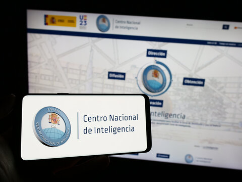 Stuttgart, Germany - 11-12-2023: Person holding mobile phone with logo of intelligency agency Centro Nacional de Inteligencia (CNI) in front of web page. Focus on phone display.