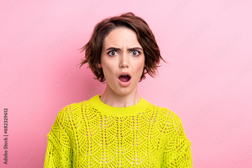 Sticker Portrait of funny young girl wearing yellow pullover shocked amazed when seen bad news on television isolated over pink color background