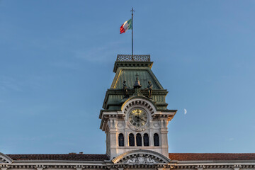 clock tower with italian flag on the town hall in Trieste, Square of Unity of Italy ( Piazza Unità d'Italia ) - obrazy, fototapety, plakaty