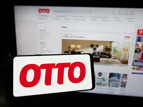 Stuttgart, Germany - 11-14-2023: Person holding smartphone with logo of German mail order company Otto GmbH Co KG in front of website. Focus on phone display.