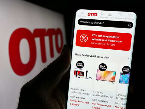 Stuttgart, Germany - 11-14-2023: Person holding cellphone with webpage of German mail order company Otto GmbH Co KG in front of business logo. Focus on center of phone display.