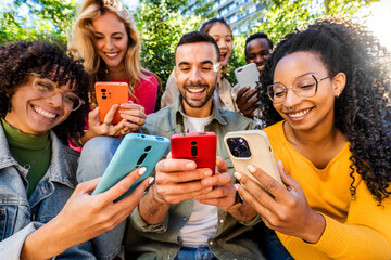 Group of young people using smart mobile phone outdoors - Happy friends with smartphone laughing together watching funny video on social media platform - Tech and modern life style concept - obrazy, fototapety, plakaty