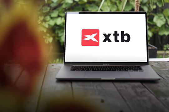 XTB logo, financial products and services supplier, displayed on MacBook Pro screen