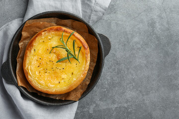 Dish with tasty baked brie cheese on grey table, top view. Space for text