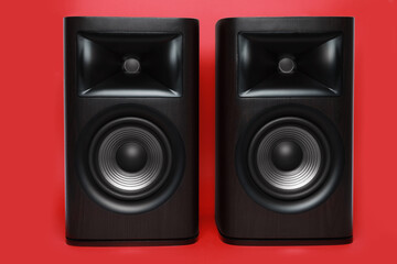 Modern wooden sound speakers on red background