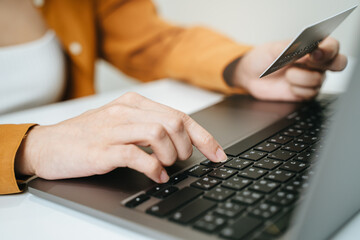 Hands of person entering credit card data laptop computer during pay for internet shopping online...