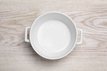 One empty pot on white wooden table, top view