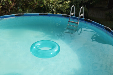 Inflatable ring floating on water in above ground swimming pool outdoors