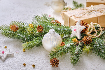 Christmas composition. Christmas tree branches, gift box with balls, cones and golden decor