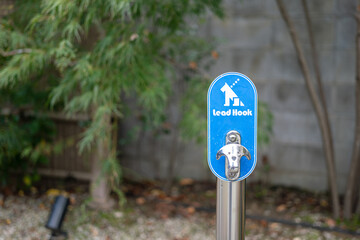 Dog leash anchor hook point which is installed in front of the restaurant. Object with sign and...
