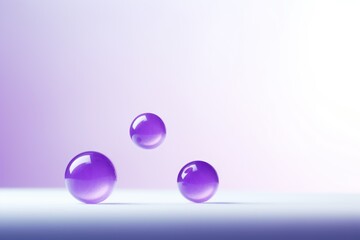  a group of three purple balls floating on top of a white surface with a light purple back ground and a light purple back ground and a light purple back ground.