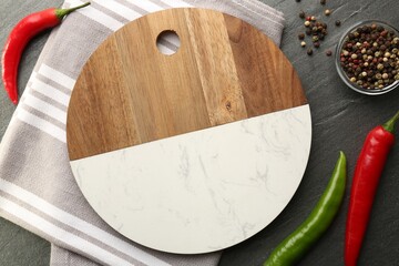Cutting board, spices and kitchen towel on dark grey table, flat lay
