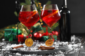 Christmas Sangria cocktail in glasses and snow on dark wooden table