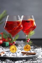 Christmas Sangria cocktail in glasses and snow on dark wooden table