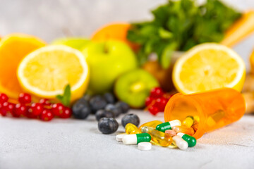 Vitamins and supplements. Variety of vitamin tablets in a jar on a texture background.Multivitamins with fresh and healthy fruits.Food supplements. Flat lay. Space for text.Copy space
