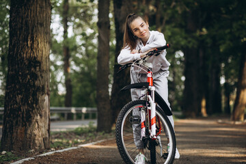 Naklejka premium Young sporty woman riding bicycle in the park
