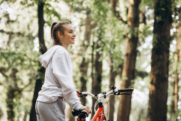 Young sporty woman riding bicycle in the park