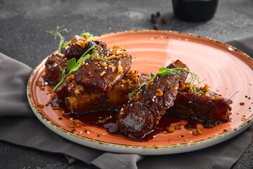BBQ glazed ribs glistening on a ceramic plate, garnished with microgreens for a minimalist presentation on a dark backdrop