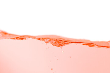 Orange water surface with splashes and bubbles on white background.