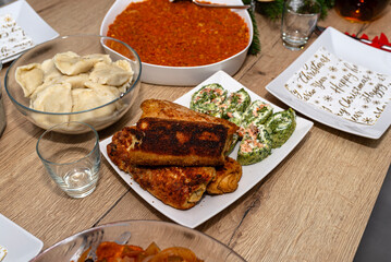 A table set before Christmas dinner in Poland, visible croquettes and a spinach roulade with salmon.