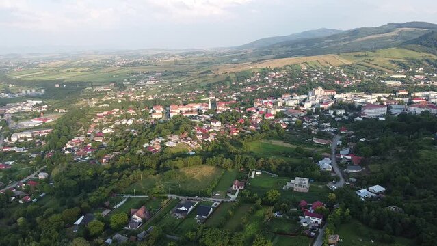 Drone footage of a small mountain city Moinesti, Bacau, Romania, with large forest
