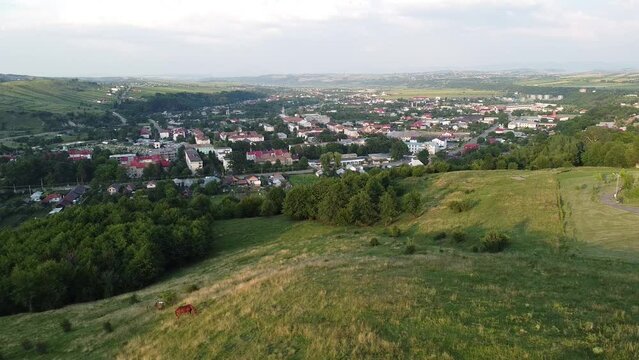 Drone footage of a small mountain city Moinesti, Bacau, Romania, with large forest