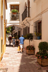 People walk through the old town of Marbella in Spain.