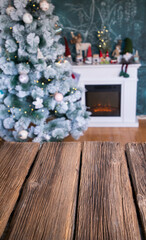 empty wooden desk Christmas tree and fireplace in the background