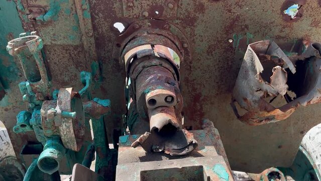 Monument to Second World War in Ukraine - an artillery cannon, fired by mistake and completely damaged, covered in traces of shrapnel against background of clouds in blue sky