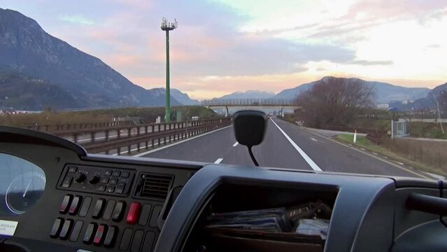 Tour Bus traveling along the Brenner pass motorway at sunset. Italy.
