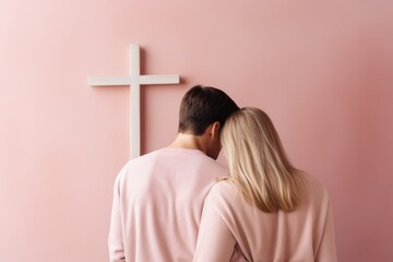 Back of fashion family couple in white clothes looking at the Cross of Jesus. Church, worship, christianity concept. Men and woman, husband, wife, bride, groom, guy and girl on pastel background - obrazy, fototapety, plakaty