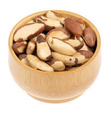 Peeled brazil nut in wooden cup isolated on white background