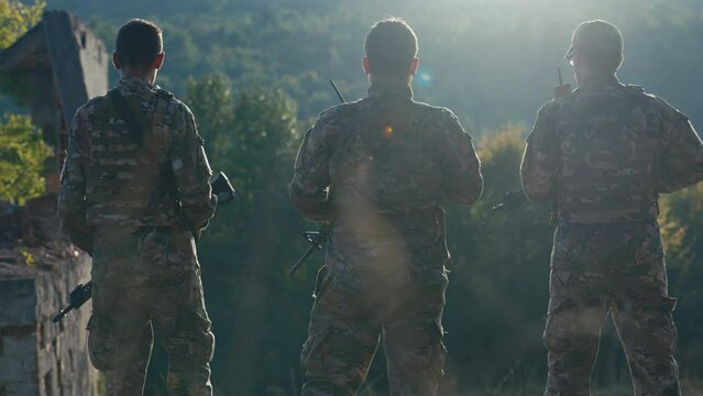 Rear View of Three Soldiers Standing on a Sunny Day