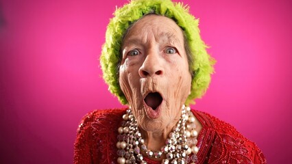 Happy fisheye portrait caricature of funny elderly woman with winner gesture having great success...