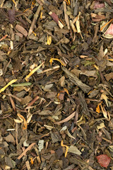 Pile leaf tea with various additives background, top view. Heap of dried tea texture
