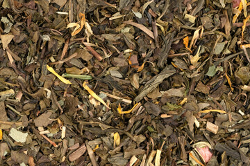 Pile leaf tea with various additives background, top view. Heap of dried tea texture