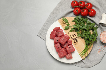 Raw beef meat and different ingredients for cooking delicious goulash on light grey table, flat...