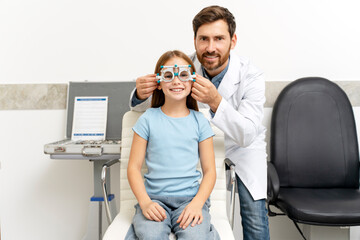 Smiling little girl sitting on chair optic office of vision test