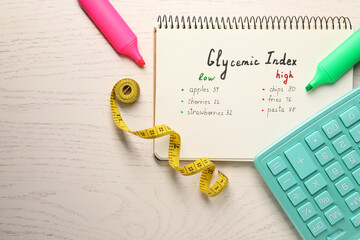List with products of low and high glycemic index in notebook, markers, measuring tape and...