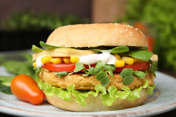 Tasty vegan burger with vegetables, patty and microgreens on white plate, closeup