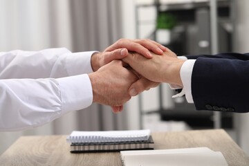 Trust and deal. Men joining hands in office, closeup